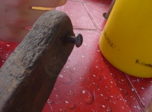 A bottle opener made with a wood stick and a screw